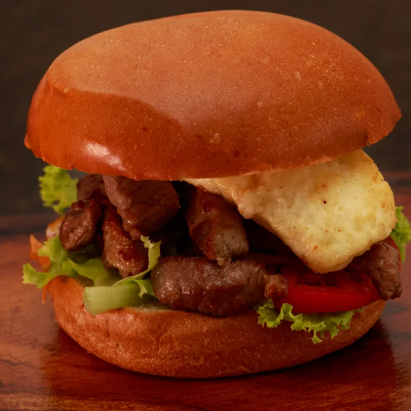 Hambúrguer de picanha com queijo e alface no pão brioche, sobre tábua de madeira